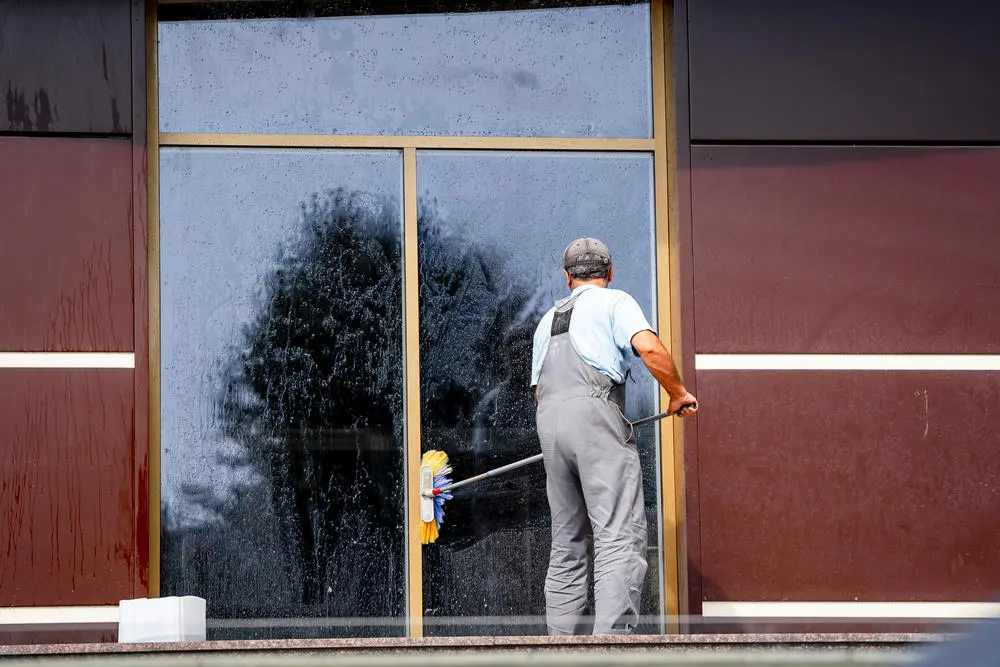Mann reinigt Fenster